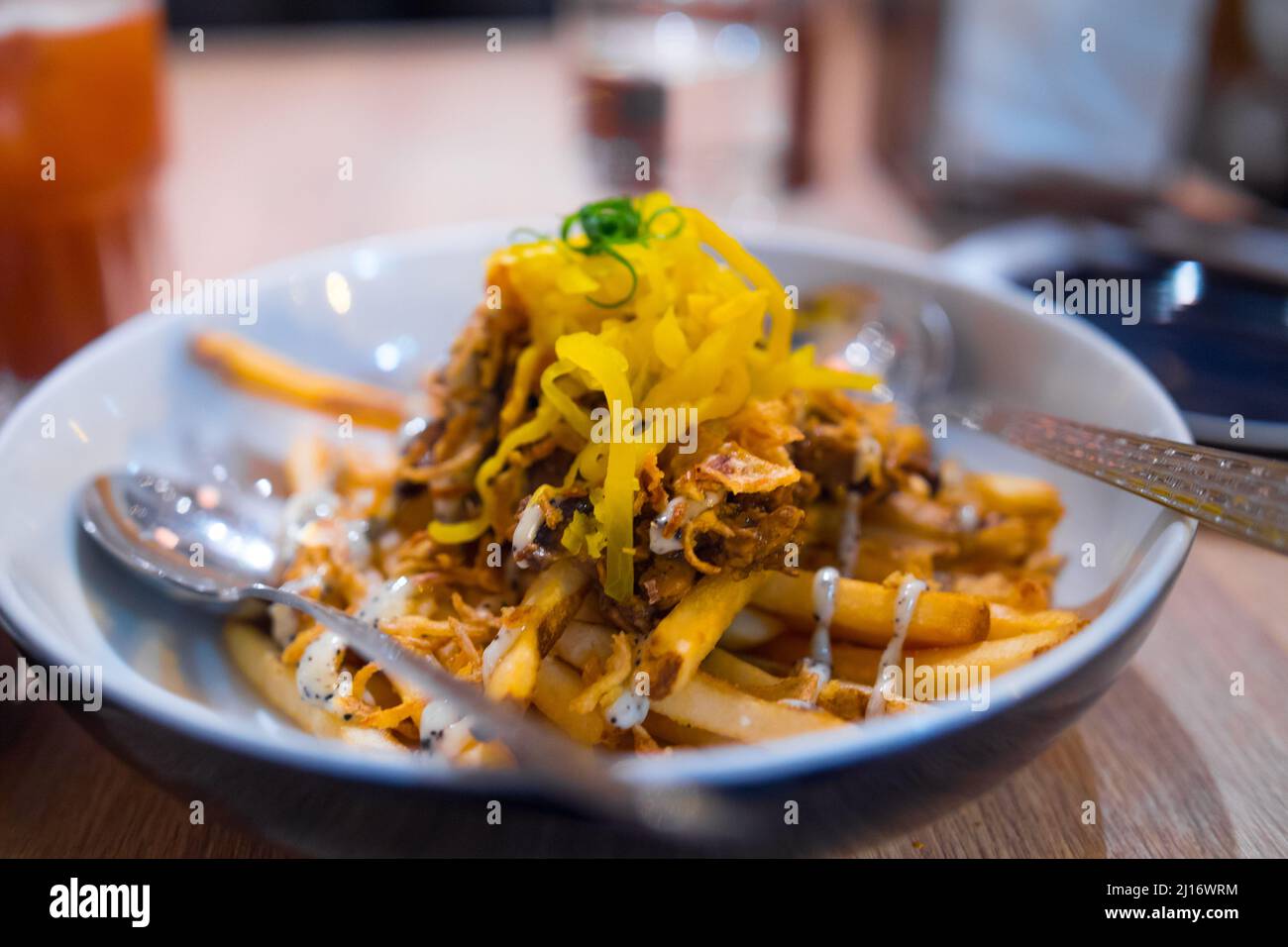 Délicieuses frites maison avec légumes, sauce aux truffes et cheddar ! Si délicieux gros plan dans le petit restaurant Bao. Banque D'Images