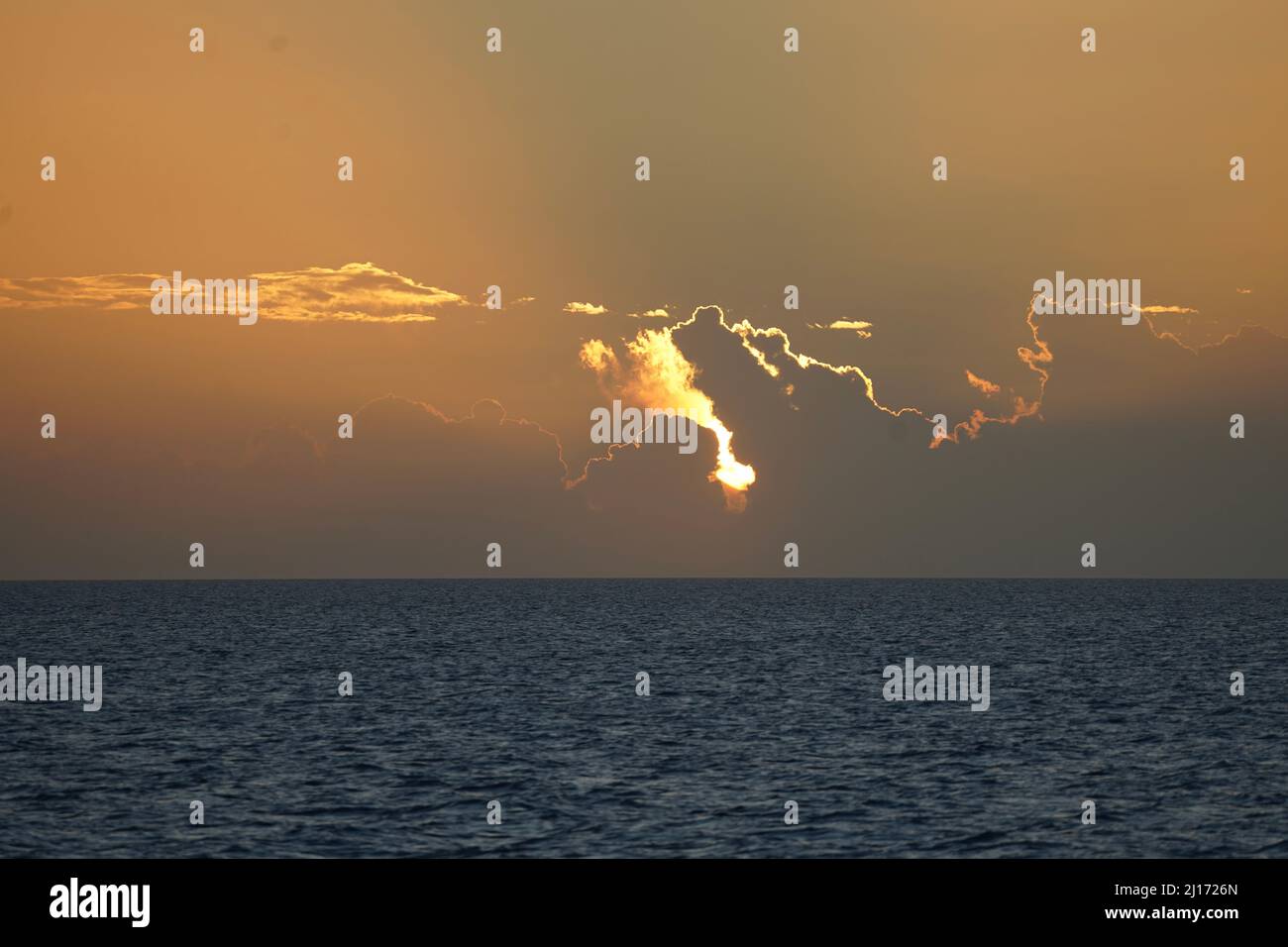 Feu derrière les nuages au coucher du soleil - Bahamas Banque D'Images