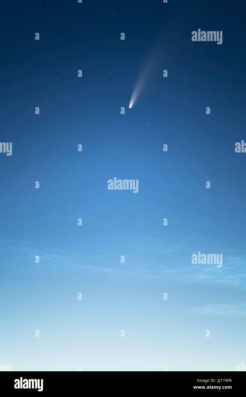 C/2020 F3 (Comet Neowise) au-dessus de nuages nocturnes dans le ciel près de Brocolitia, parc national de Northumberland, Angleterre Banque D'Images