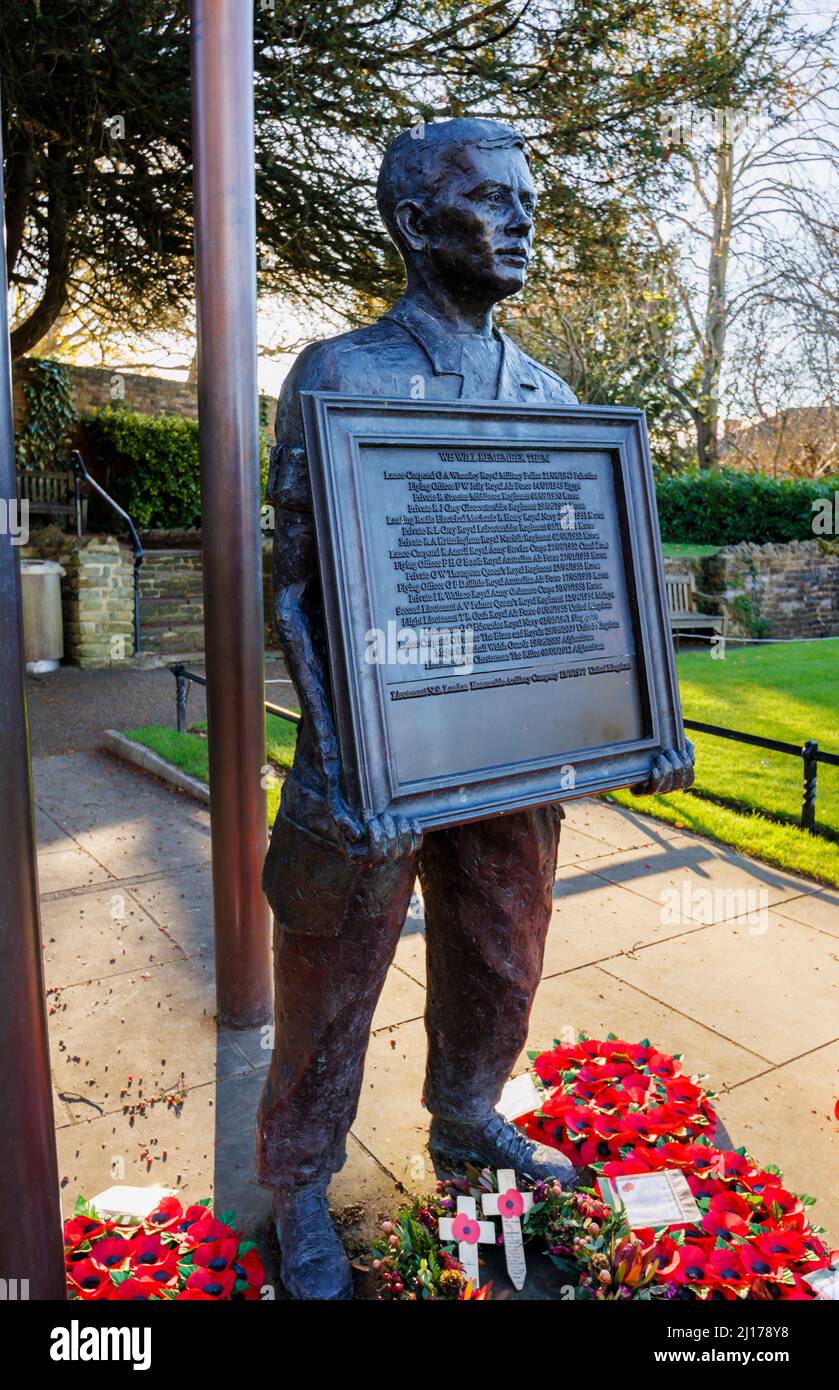 Statue du souvenir d'un homme tenant une liste des morts inscrits