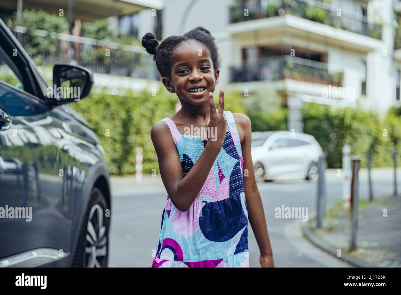 Bonne fille faisant signe de paix sur la route Banque D'Images