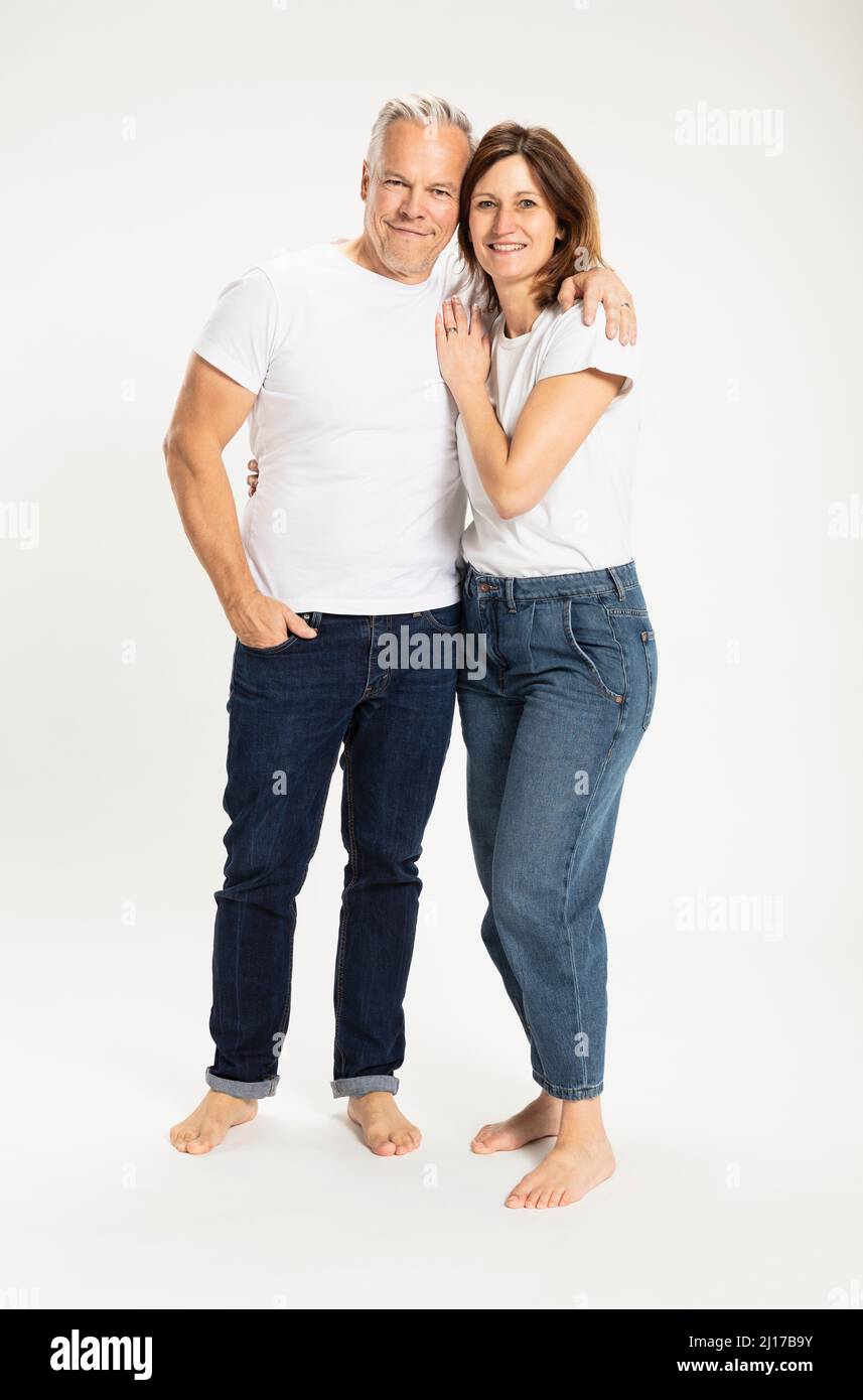 Homme heureux avec une femme debout avec le bras autour sur fond blanc Banque D'Images