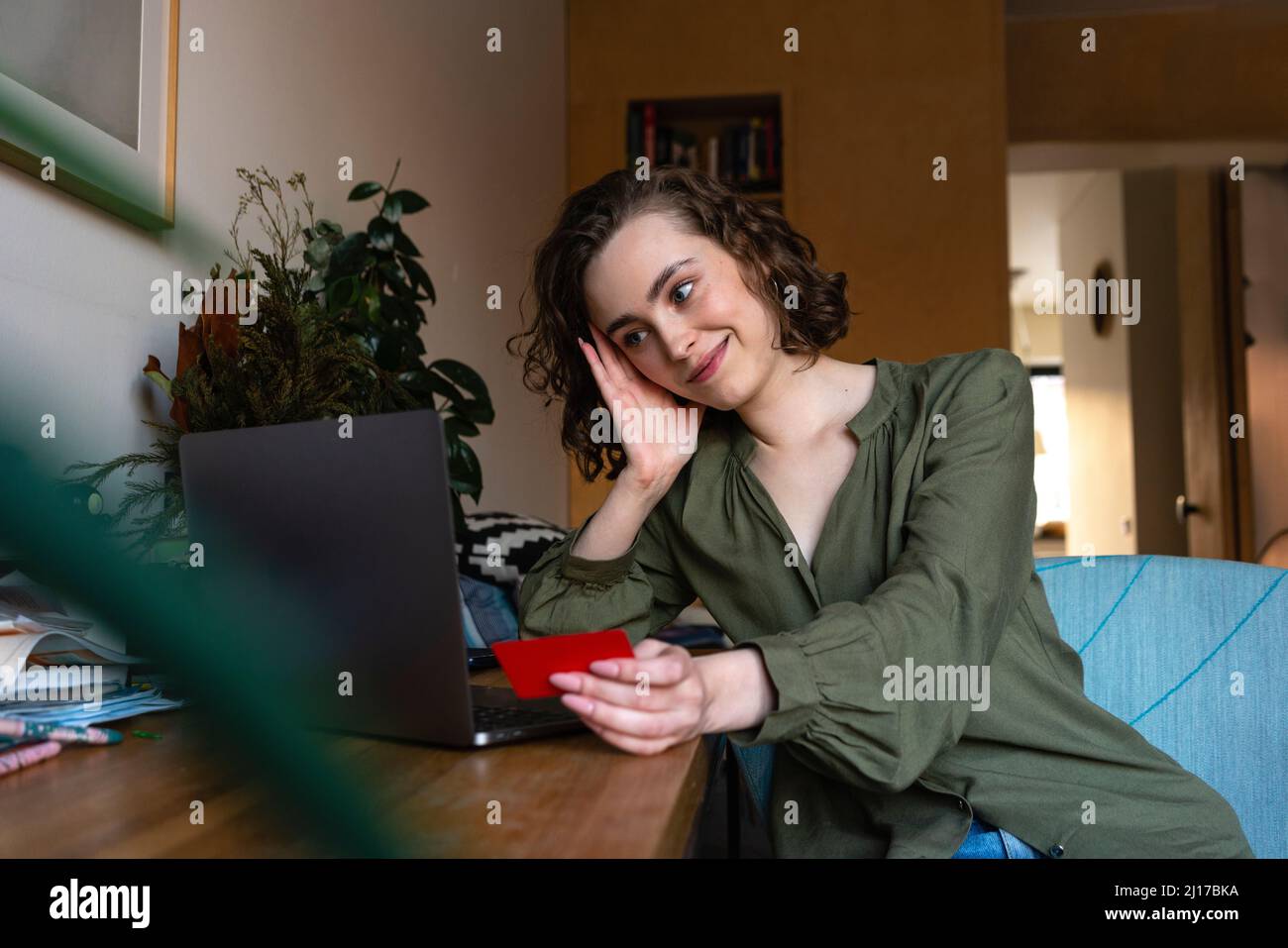 Jeune femme souriante avec carte regardant l'ordinateur portable Banque D'Images
