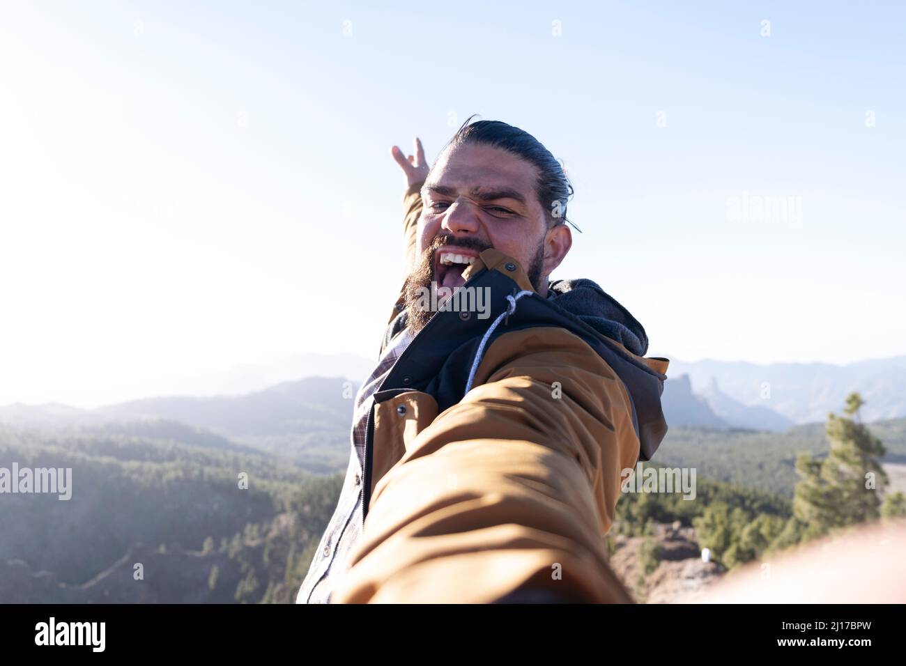 Homme avec la bouche ouverte prenant le selfie le jour ensoleillé Banque D'Images
