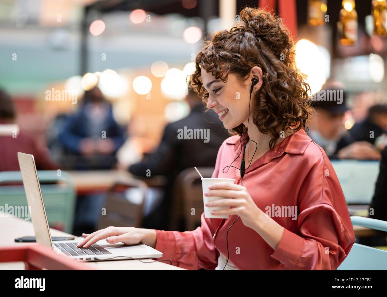 Young businesswoman typing on laptop at cafe Banque D'Images