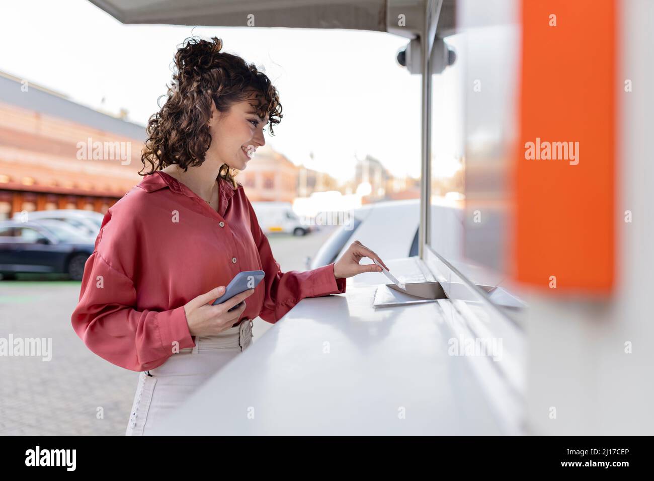 Jeune femme montrant le billet au comptoir d'enregistrement Banque D'Images