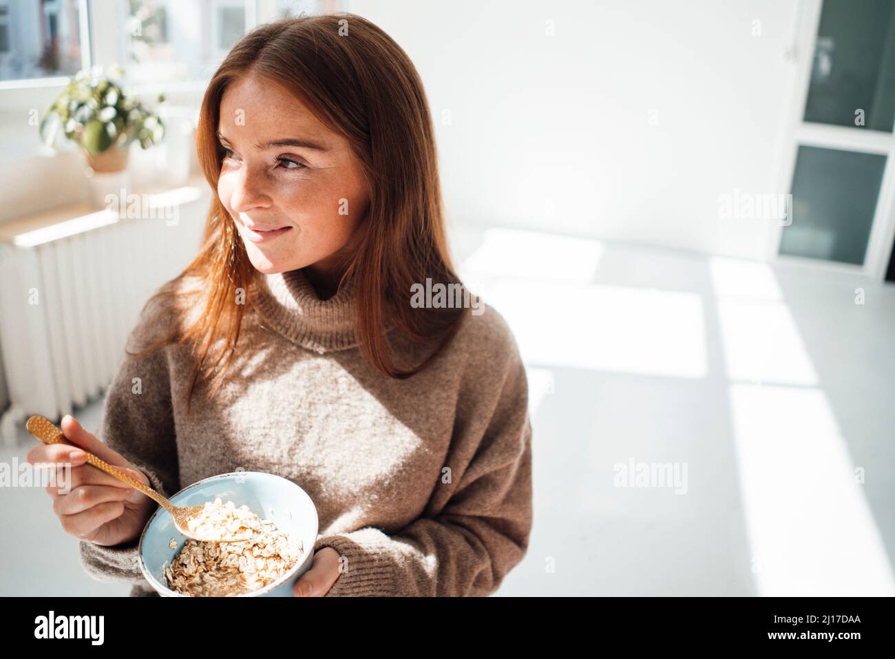 Femme attentionnés avec bol à céréales à la maison Banque D'Images Femme attentionnés avec bol à céréales à la maison Banque D'Images