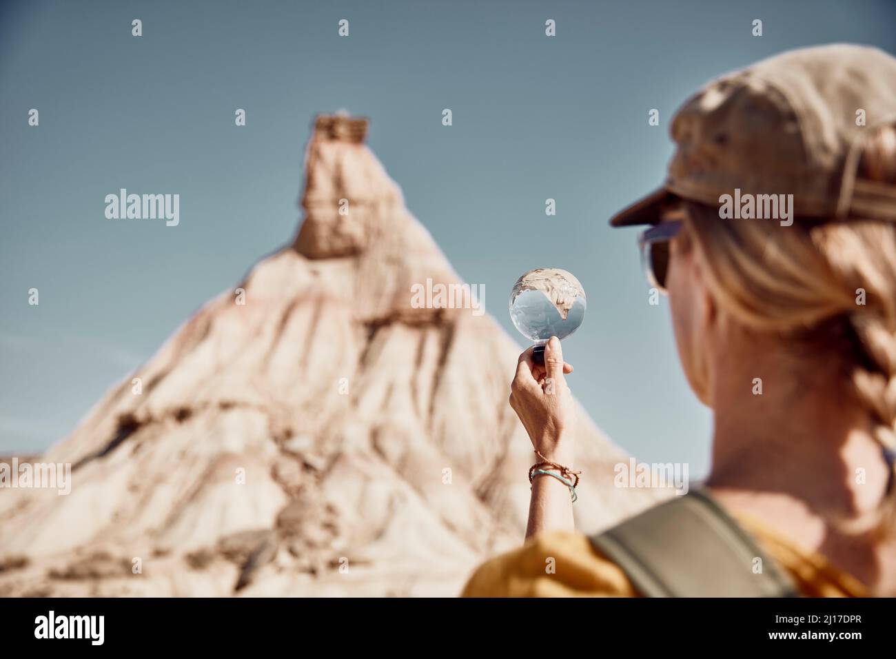 Femme regardant la montagne à travers la loupe le jour ensoleillé Banque D'Images