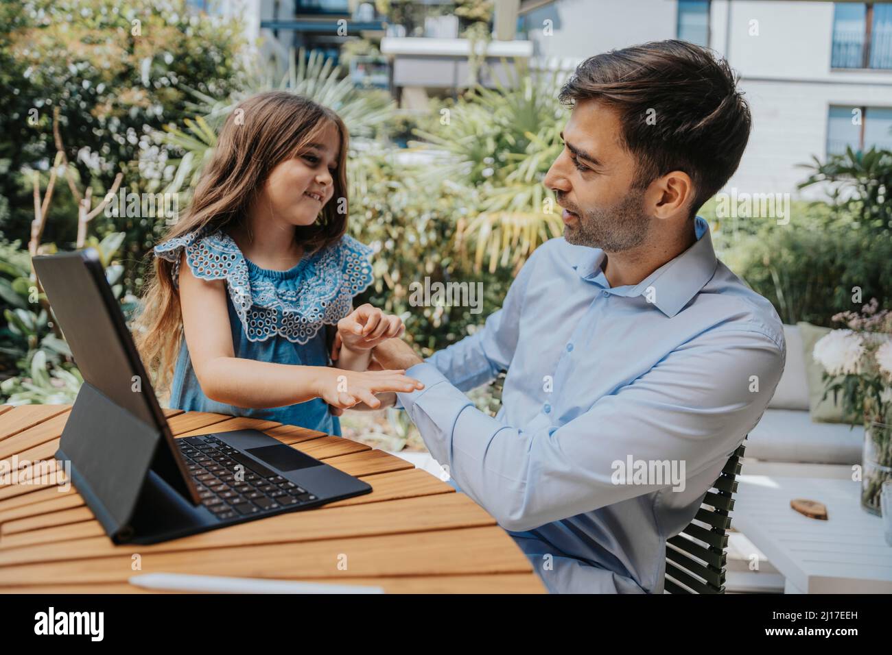 Homme d'affaires parlant avec sa fille dans la cour arrière Banque D'Images
