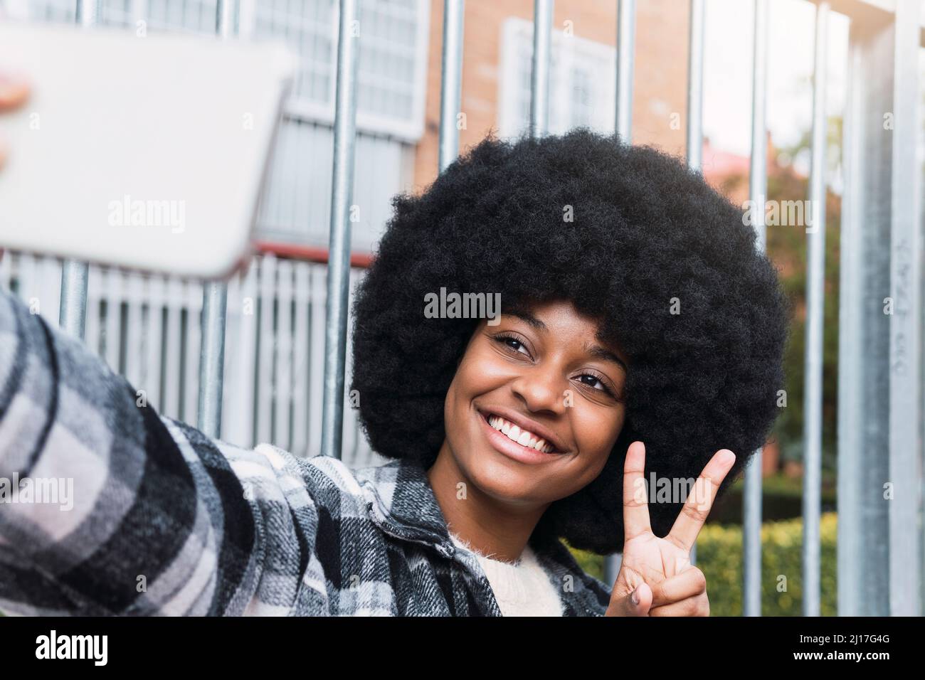 Une femme heureuse prenant un selfie montrant le signe de la paix Banque D'Images