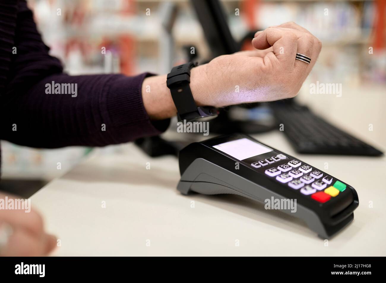 Homme effectuant un paiement sans contact par Smart Watch au comptoir de caisse du magasin Banque D'Images