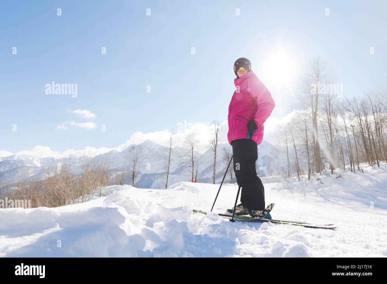 Homme dans des vêtements chauds debout avec des skis sur la neige en hiver Banque D'Images