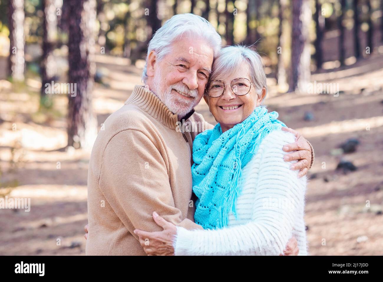 Couple senior heureux s'embrassant dans la forêt Banque D'Images