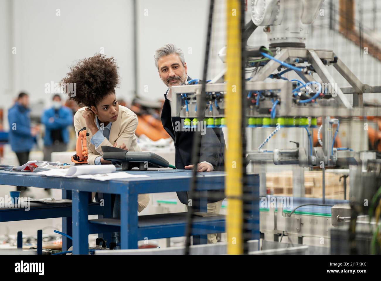 Ingénieurs examinant les machines en usine Banque D'Images