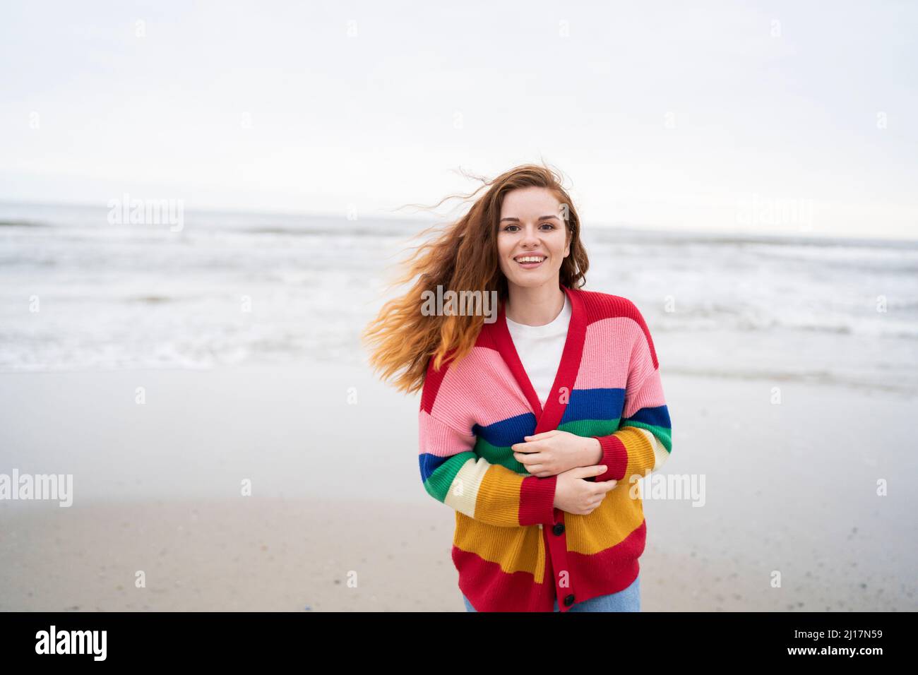 Joyeuse femme rouge appréciant à la plage Banque D'Images