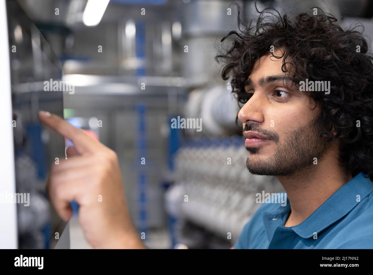 Technicien utilisant l'écran tactile de la machine en usine Banque D'Images