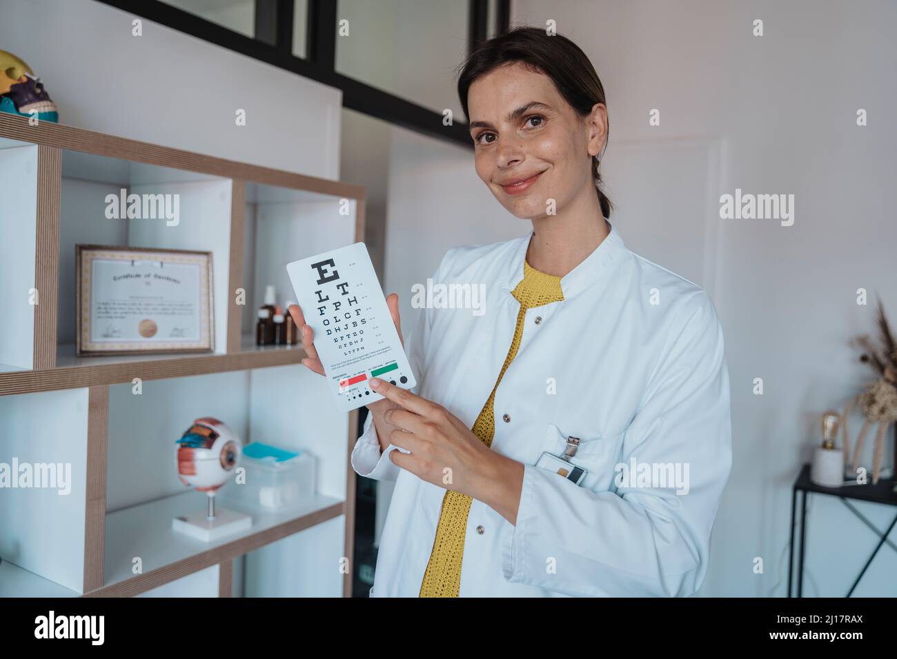 Médecin pointant vers le diagramme de l'œil en clinique Banque D'Images