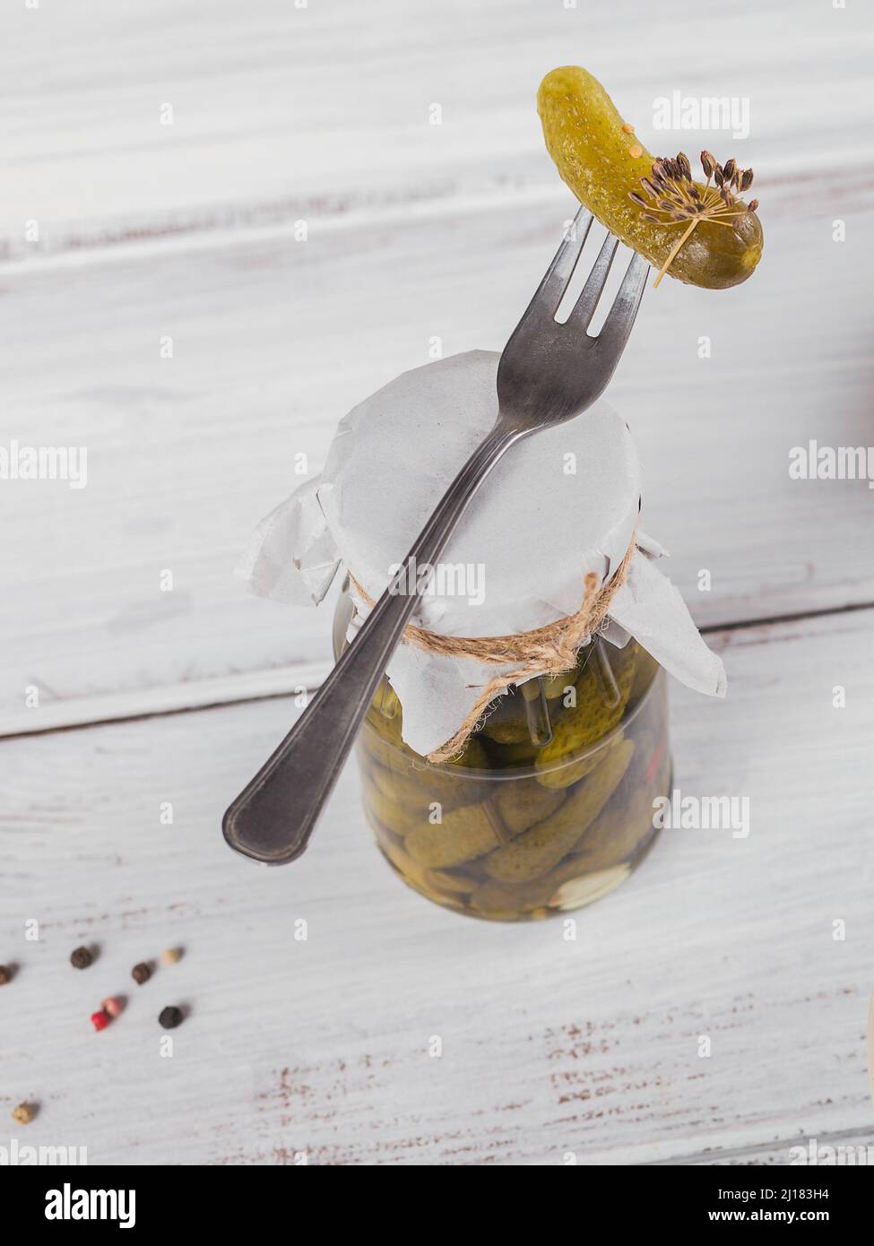 Conserver les concombres marinés, les assaisonnements et l'ail sur une table en bois blanc. Aliments fermentés sains. Légumes en conserve à la maison. Banque D'Images