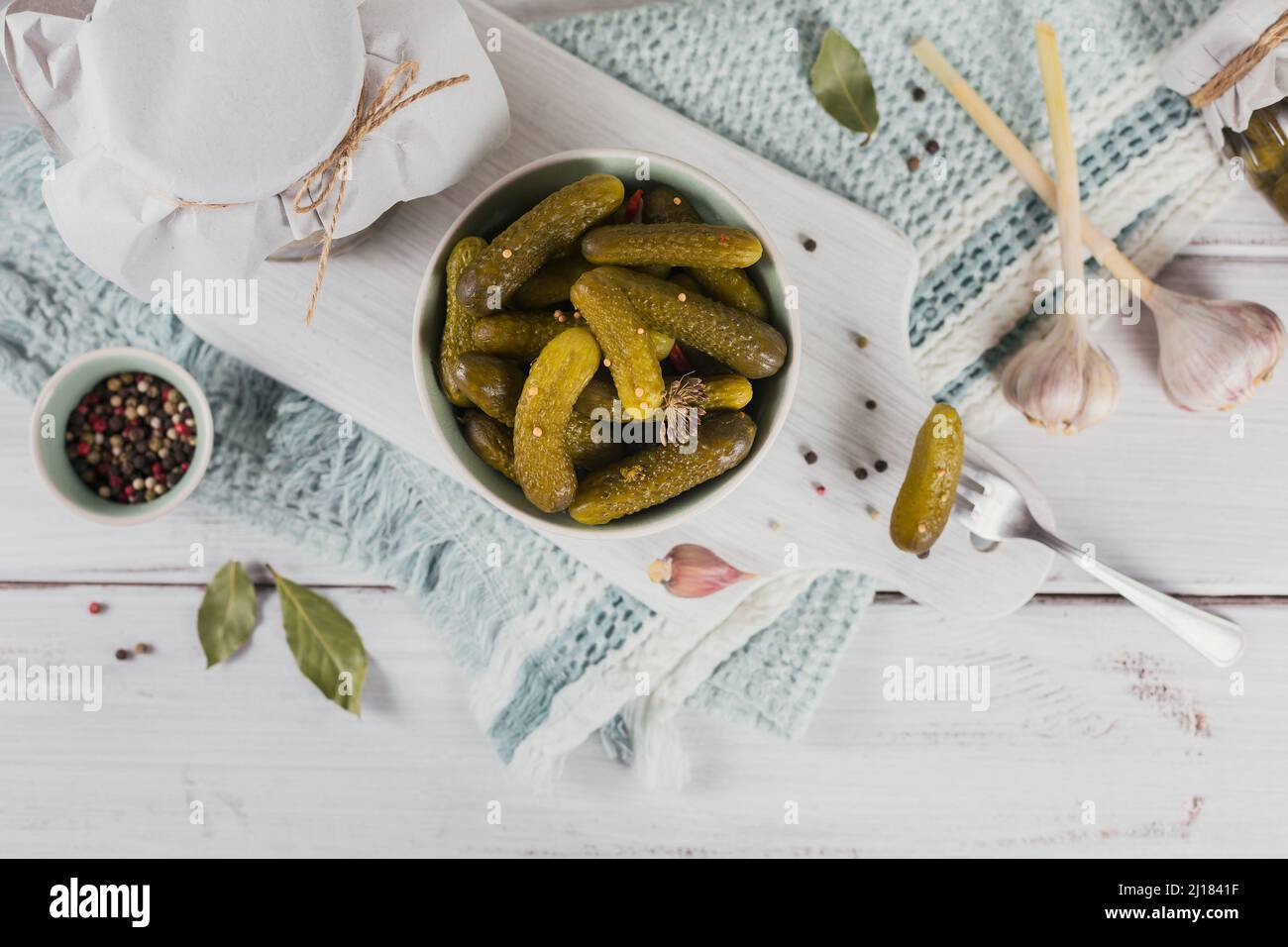Conserver les concombres marinés, les assaisonnements et l'ail sur une table en bois blanc. Aliments fermentés sains. Légumes en conserve à la maison. Banque D'Images