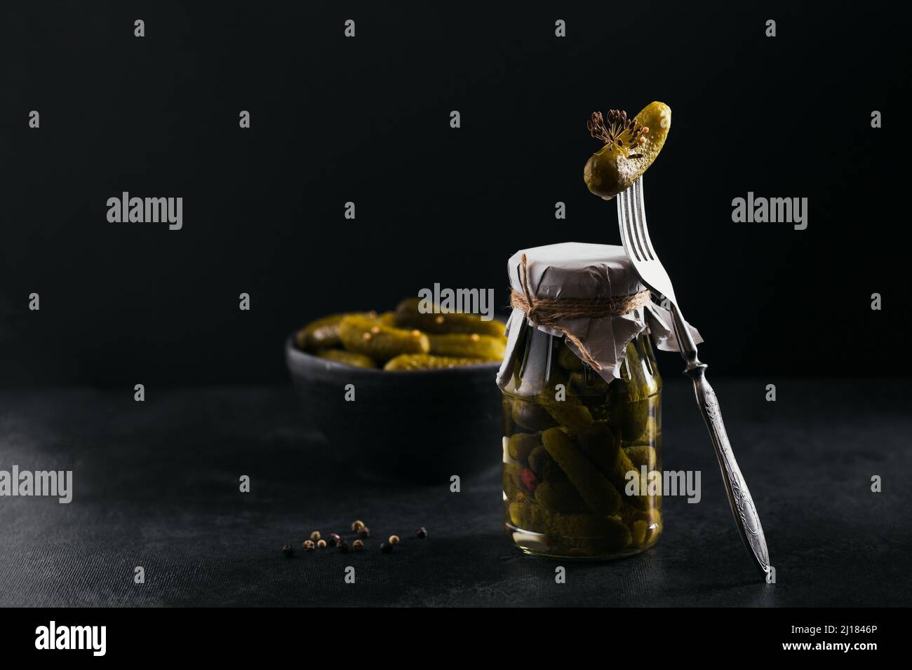 Conserver les concombres marinés, les assaisonnements et l'ail sur une table sombre. Aliments fermentés sains. Légumes en conserve à la maison. Banque D'Images