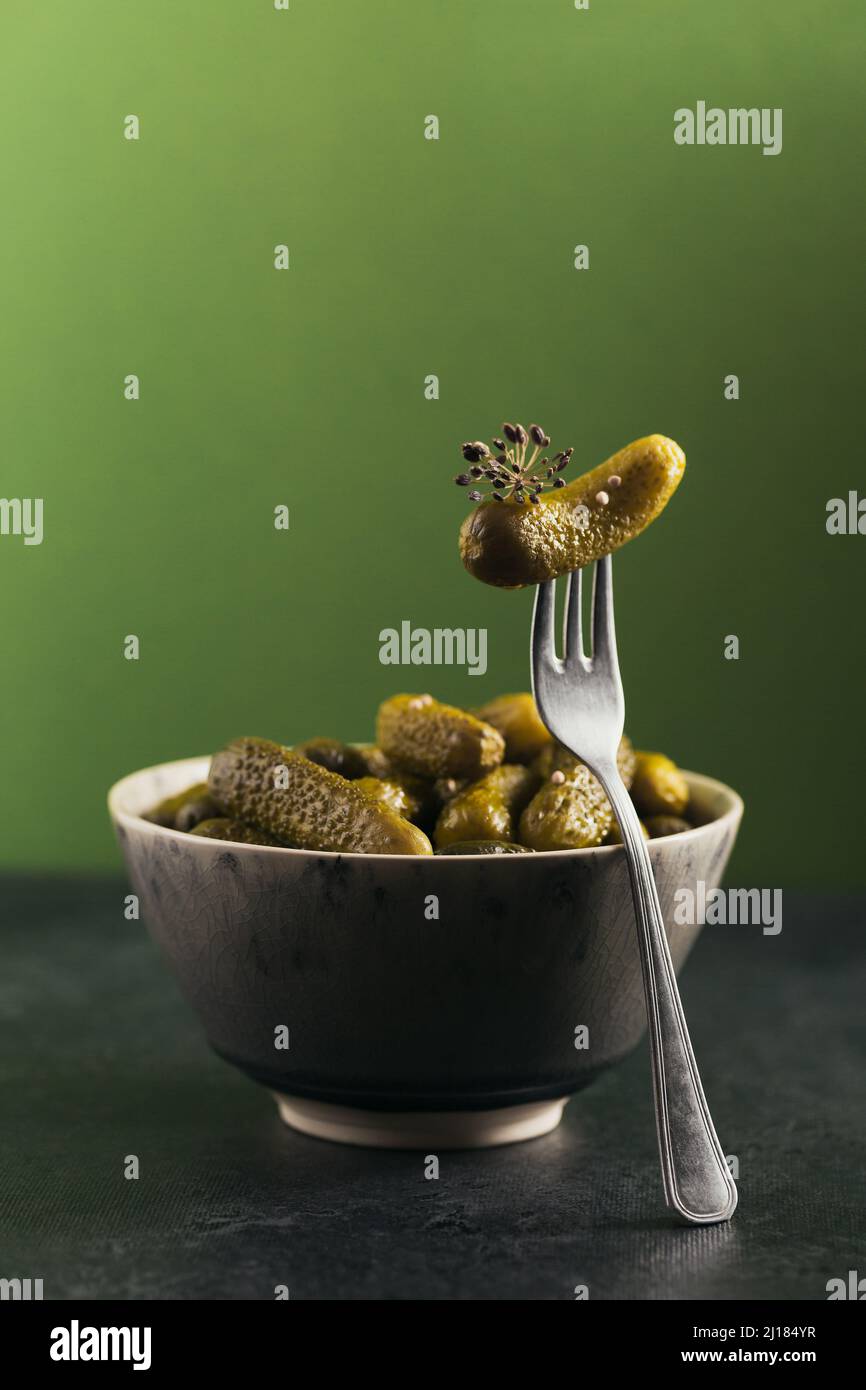 Conserver les concombres marinés, les assaisonnements et l'ail sur un fond vert. Aliments fermentés sains. Légumes en conserve à la maison. Banque D'Images