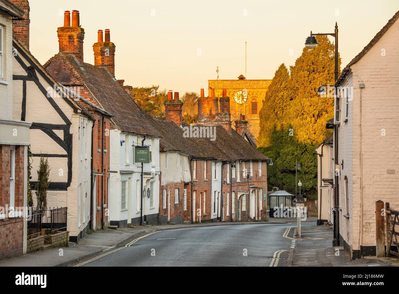 Maisons le long de George Street avec l'église St Mary au lever du soleil, Kingsclere, Hampshire, Angleterre, Royaume-Uni, Europe Banque D'Images