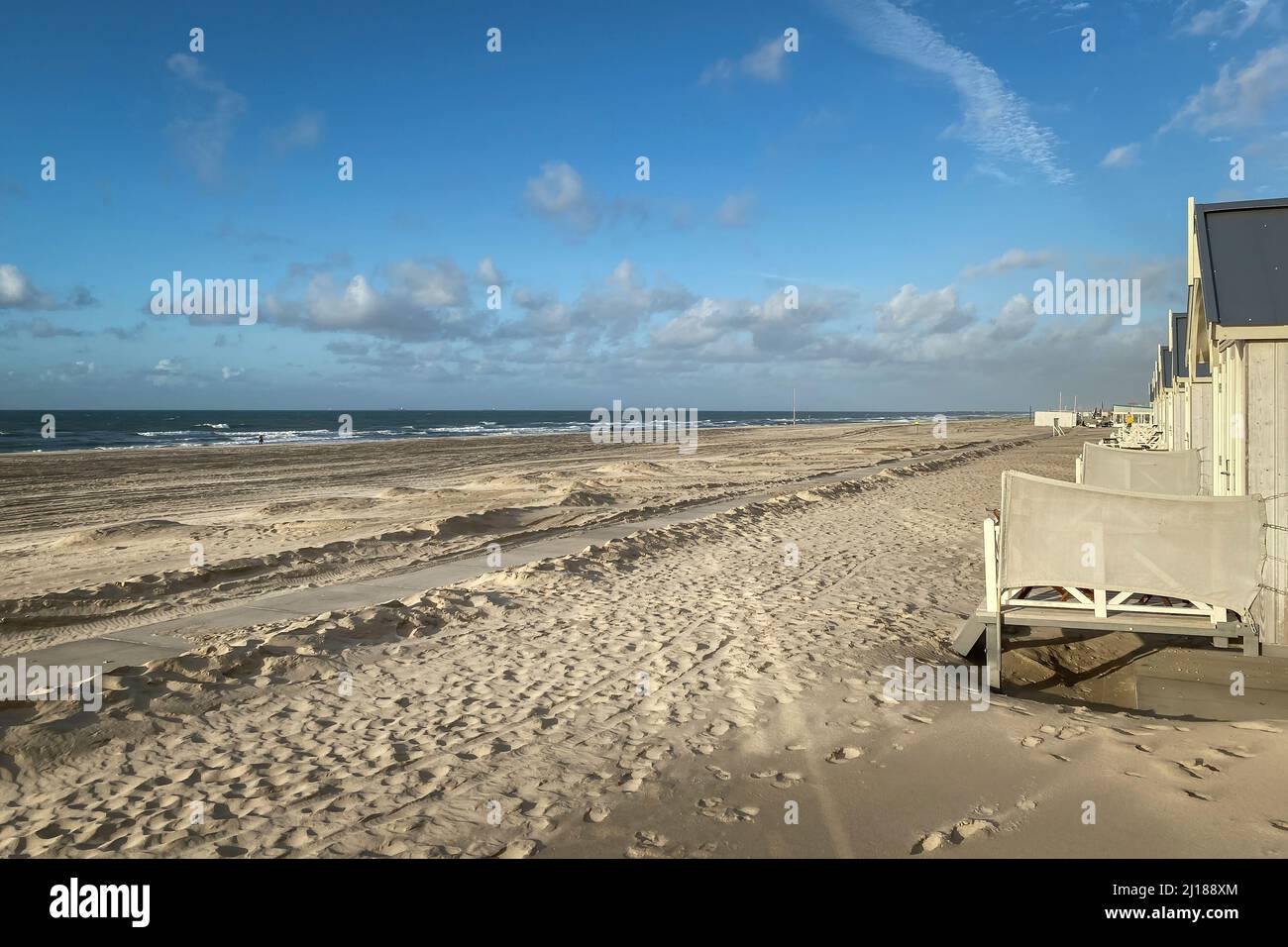 Vue panoramique sur les cabanes de plage à la plage de la mer du Nord à Kijkduin, pays-Bas contre le soleil et le ciel Banque D'Images