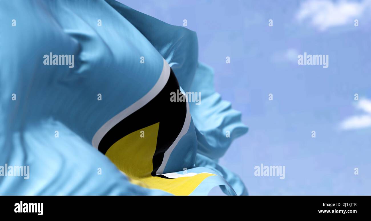 Détail du drapeau national de Sainte-Lucie qui agite dans le vent par temps clair. Sainte-Lucie est un pays insulaire des Antilles. Mise au point sélective. Banque D'Images