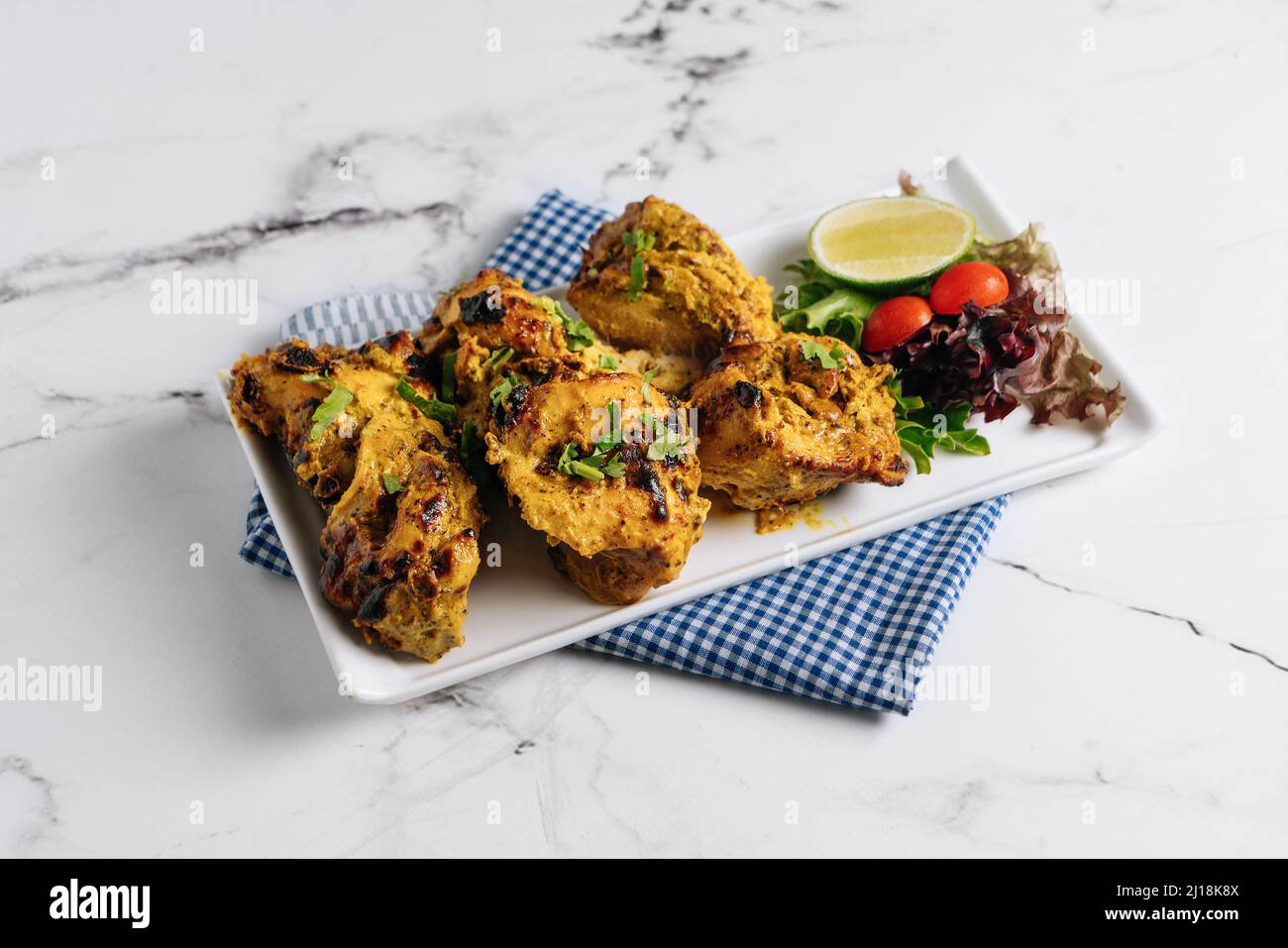 Kali Mirchi ou boeuf au poivre noir Kebab avec de la chaux dans un plat isolé sur le côté de serviette vue sur fond gris Banque D'Images