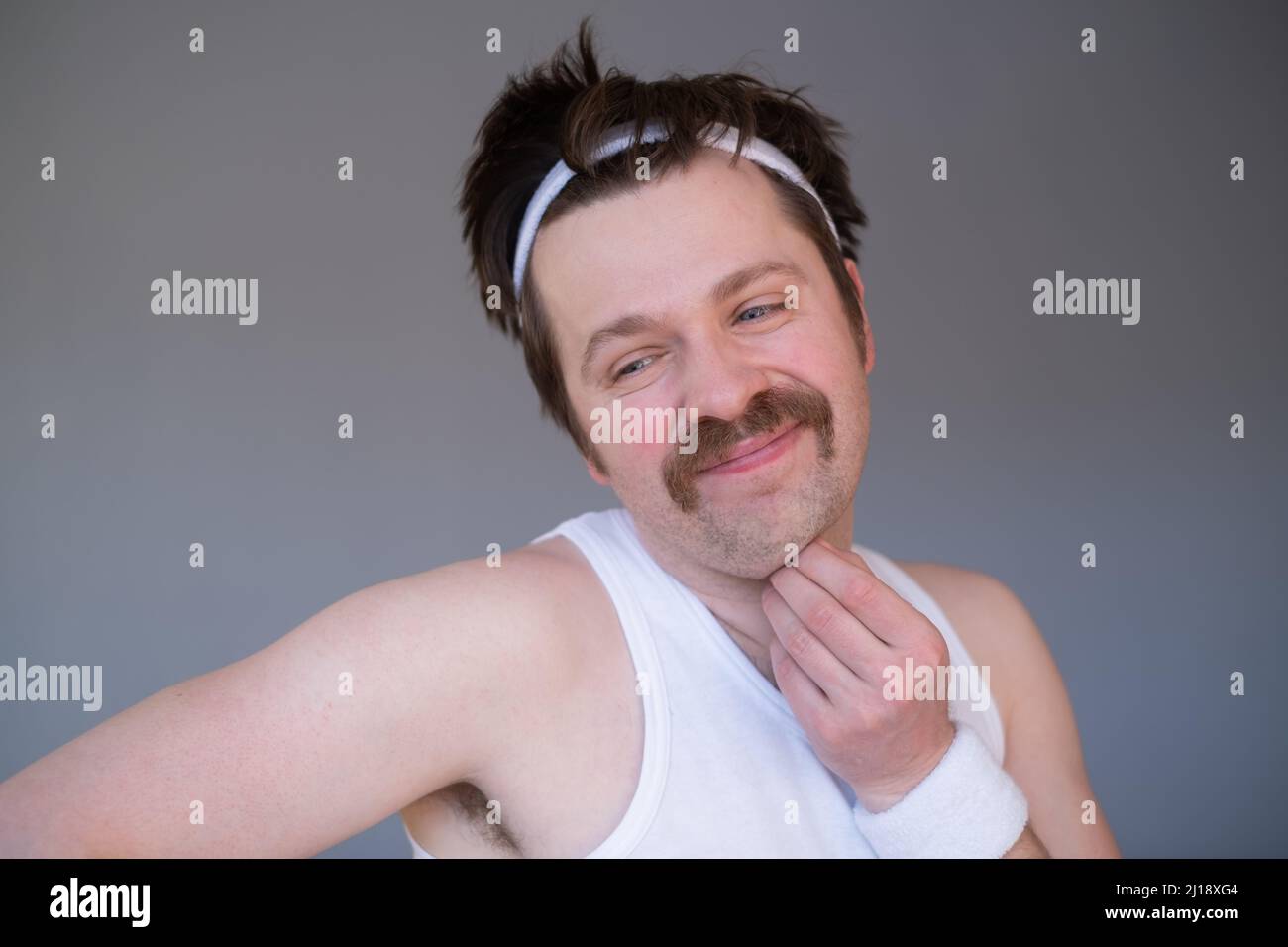 Athlétique drôle jeune homme faisant l'exercice haltères. Studio tourné sur une photo jaune Banque D'Images