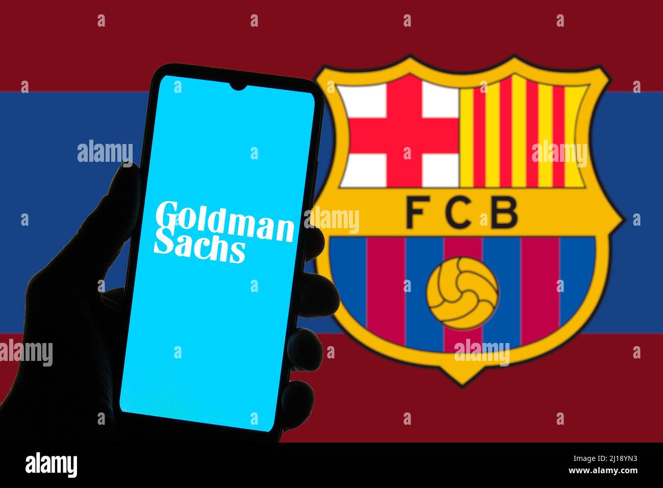 Sur cette photo, un logo du groupe Goldman Sachs apparaît sur un smartphone avec un logo du football Club Barcelona (FCB) en arrière-plan. Banque D'Images