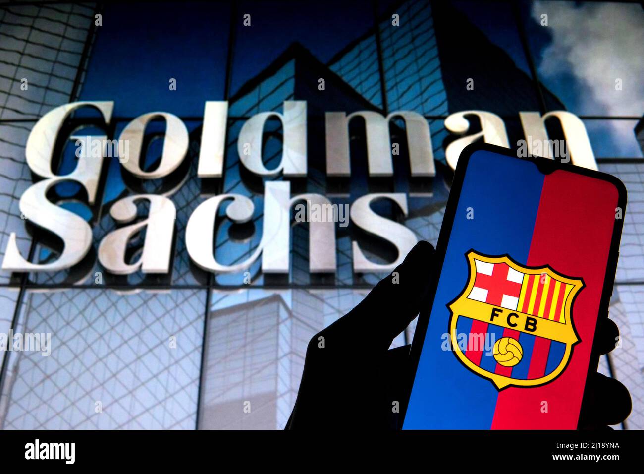 Sur cette photo, un logo du football Club Barcelona (FCB) apparaît sur un smartphone avec un logo du groupe Goldman Sachs en arrière-plan. Banque D'Images