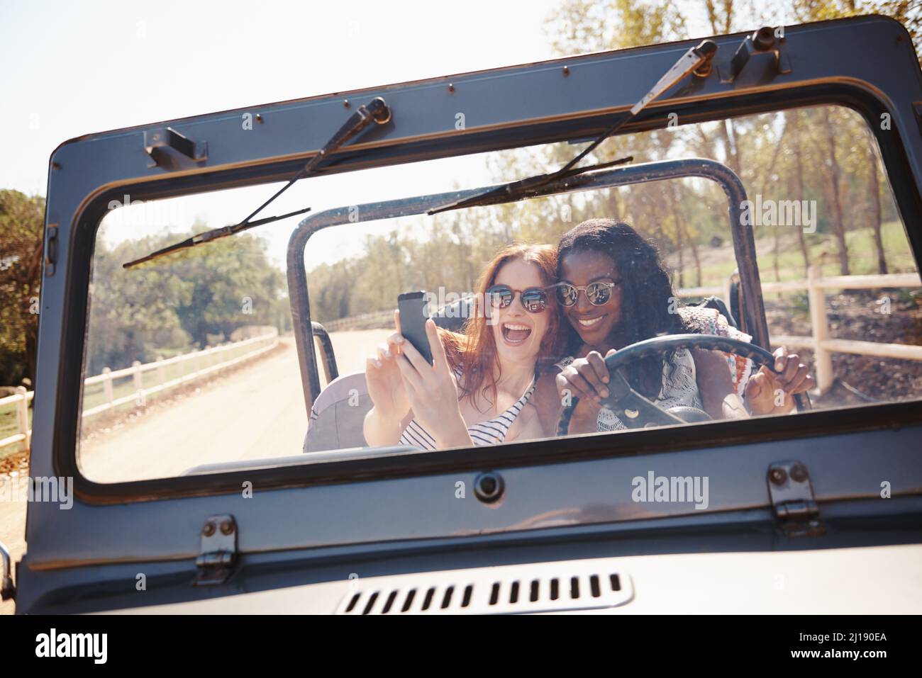 conduite de selfie. Photo de deux jeunes femmes attirantes prenant un selfie dans la voiture. Banque D'Images