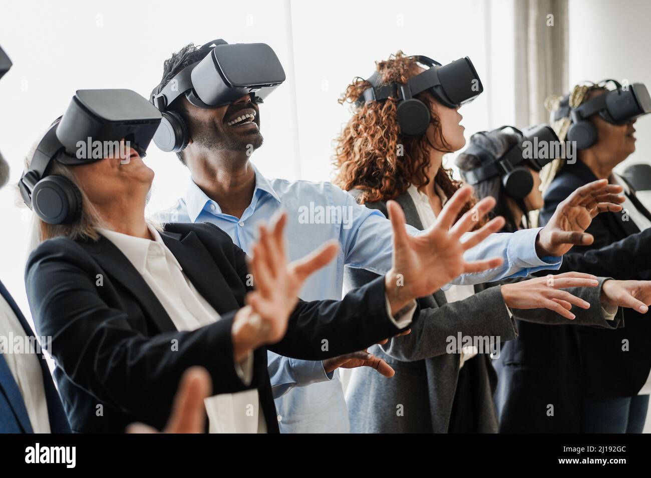 Travail d'équipe multiracial s'amuser à porter un casque de réalité virtuelle dans le bureau de collègue - Focus sur le visage d'homme indien Banque D'Images