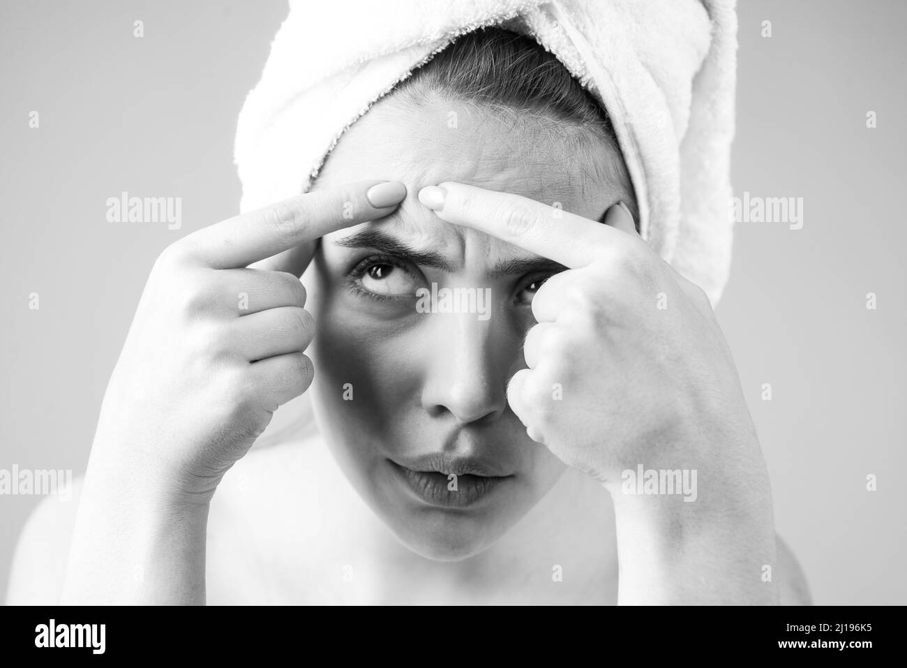 Gros plan femme appuyant des boutons sur son visage.Taches de défaut d