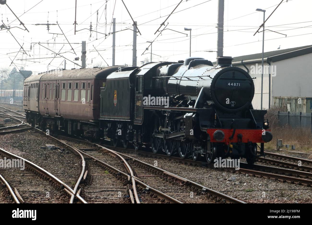 Train à vapeur Stanier Black Five conservé, 44871, quittant le chemin de fer de la West Coast main Line lorsqu'il arrive à Carnforth le 23rd mars 2022. Banque D'Images