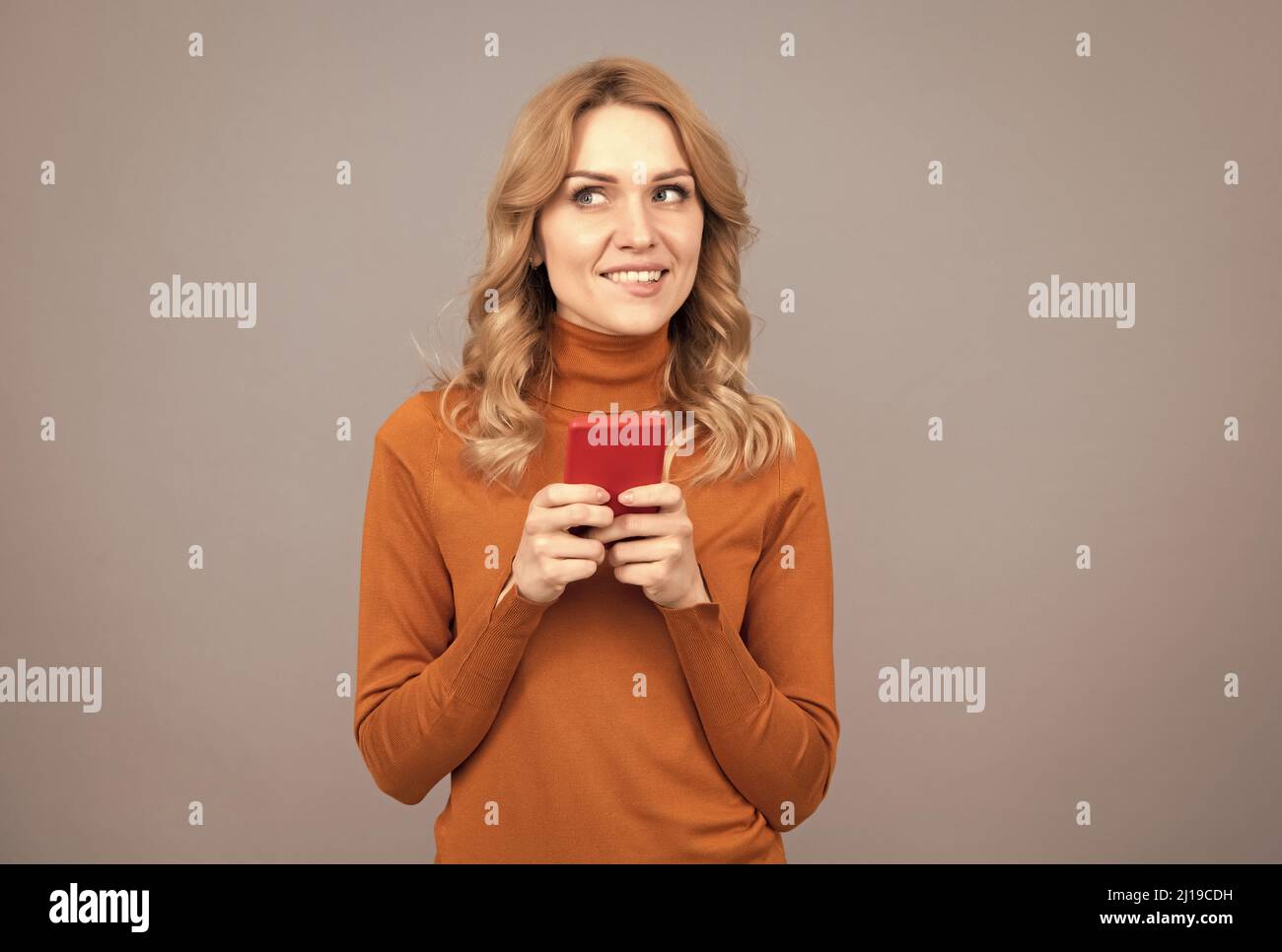 Soyez plus intelligent. Jolie fille SMS texte sur smartphone. Profitez d'Internet avec le dernier smartphone Banque D'Images