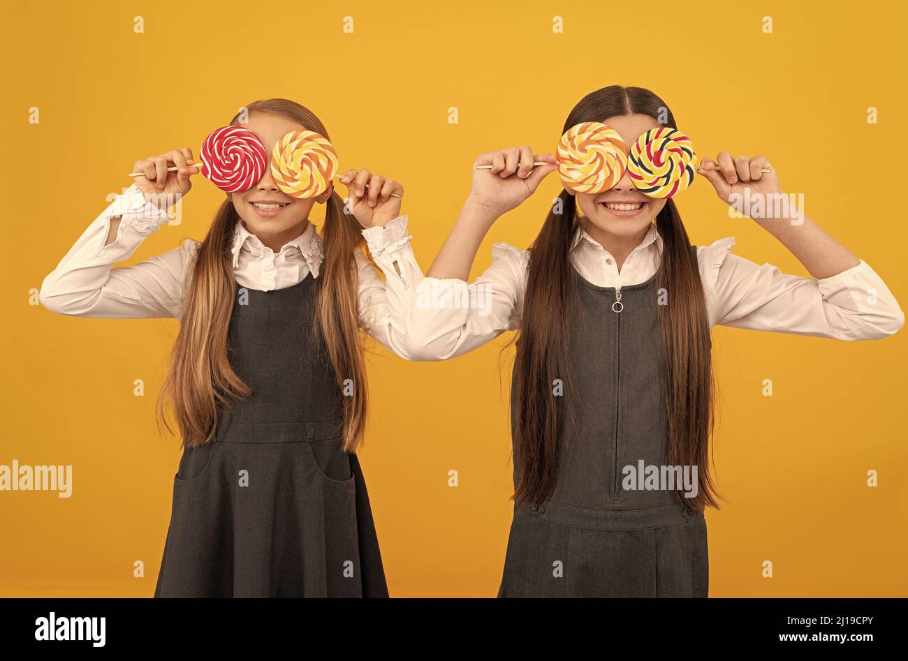 Look élégant. Les élèves amusants couvrent les yeux avec des sucettes. Éducation scolaire. Une vie toujours douce. Profitez-en aujourd'hui Banque D'Images