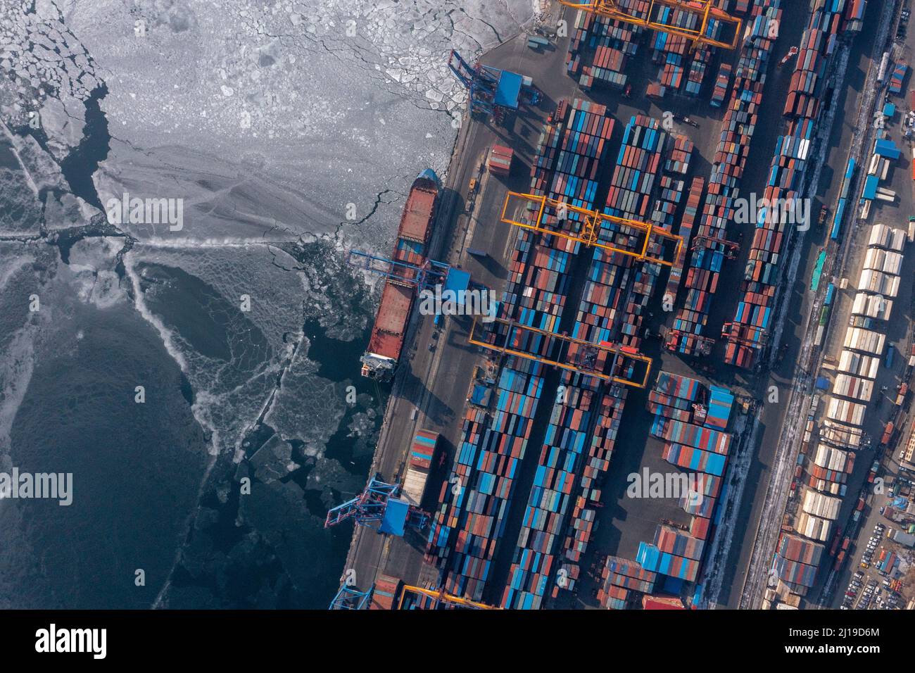 Vladivostok, Russie - 27 janvier 2022 : Vue de dessus du terminal des conteneurs du port maritime. En hiver, un bateau à conteneurs est en train de charger au quai. Banque D'Images