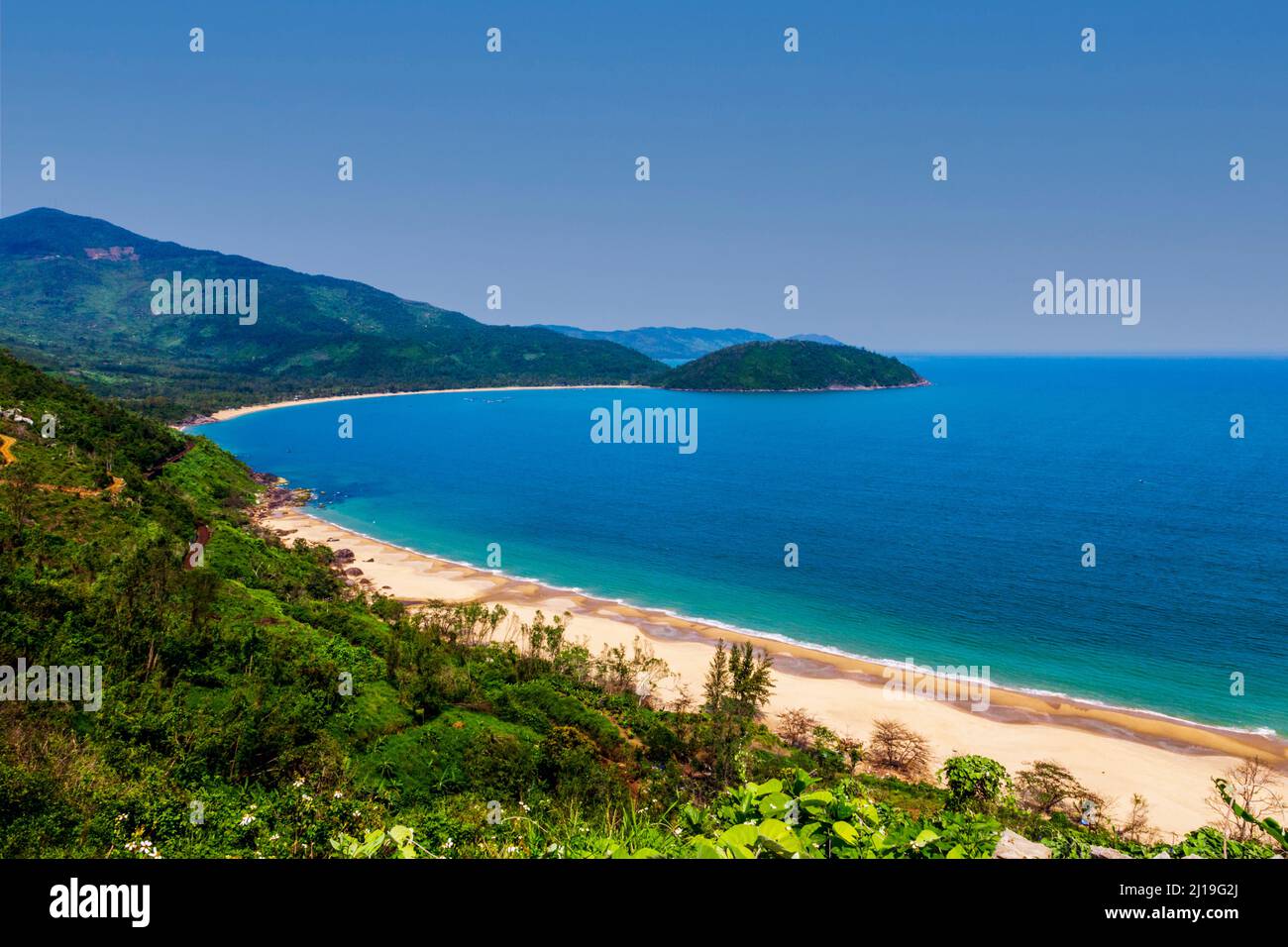 Une magnifique crique avec une plage de sable juste au nord de Da nang. Eau bleue avec végétation verte sur la montagne. Banque D'Images