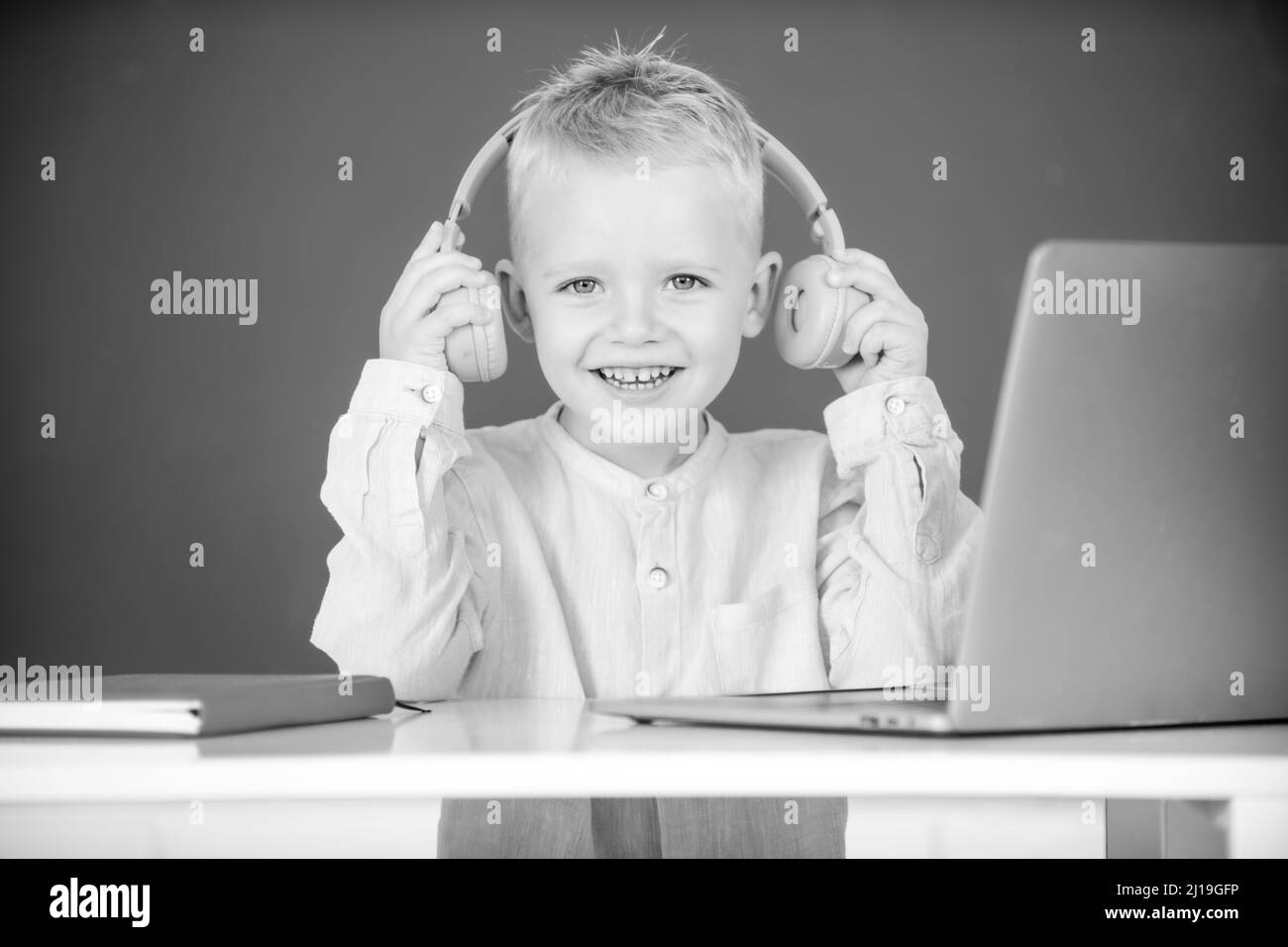 Enfant garçon dans le casque d'étude en ligne, enfant dans les écouteurs de prendre la leçon Web d'Internet.Journée des connaissances. Banque D'Images