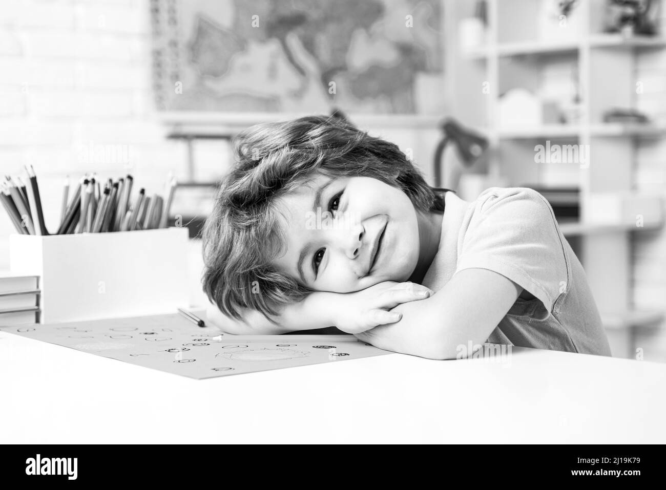 Portrait d'un élève élémentaire regardant l'appareil photo. Apprendre par un jeune enfant ou un jeune enfant. Portrait de l'élève de l'école primaire étudier à l'intérieur. Enseignement à domicile. Banque D'Images