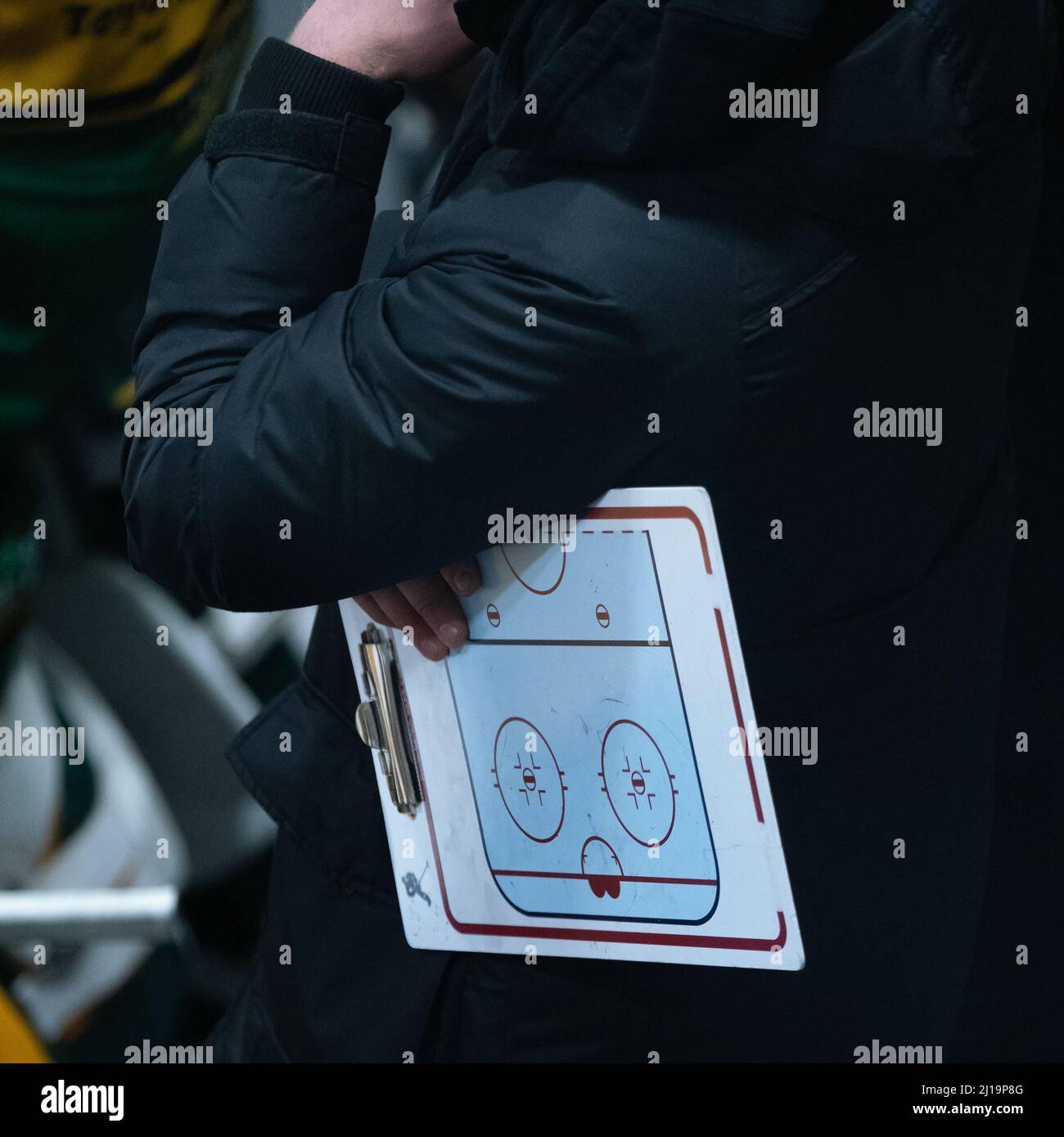 Helsinki / Finlande - 22 MARS 2022 : un entraîneur de hockey sur glace tient un tableau de conférence tout en regardant le match Banque D'Images