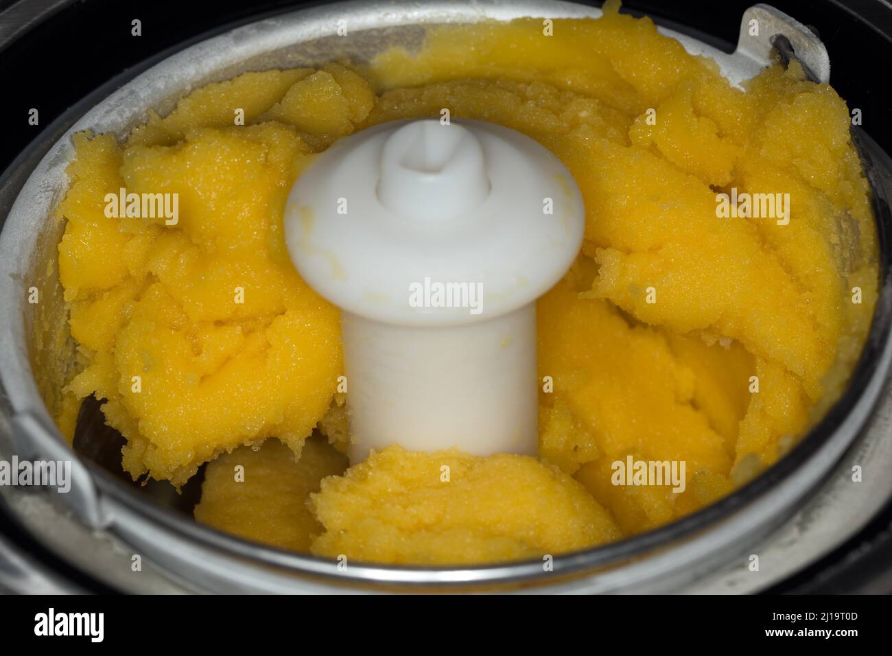 Sorbet à la mangue surgelé dans une machine à crème glacée Banque D'Images