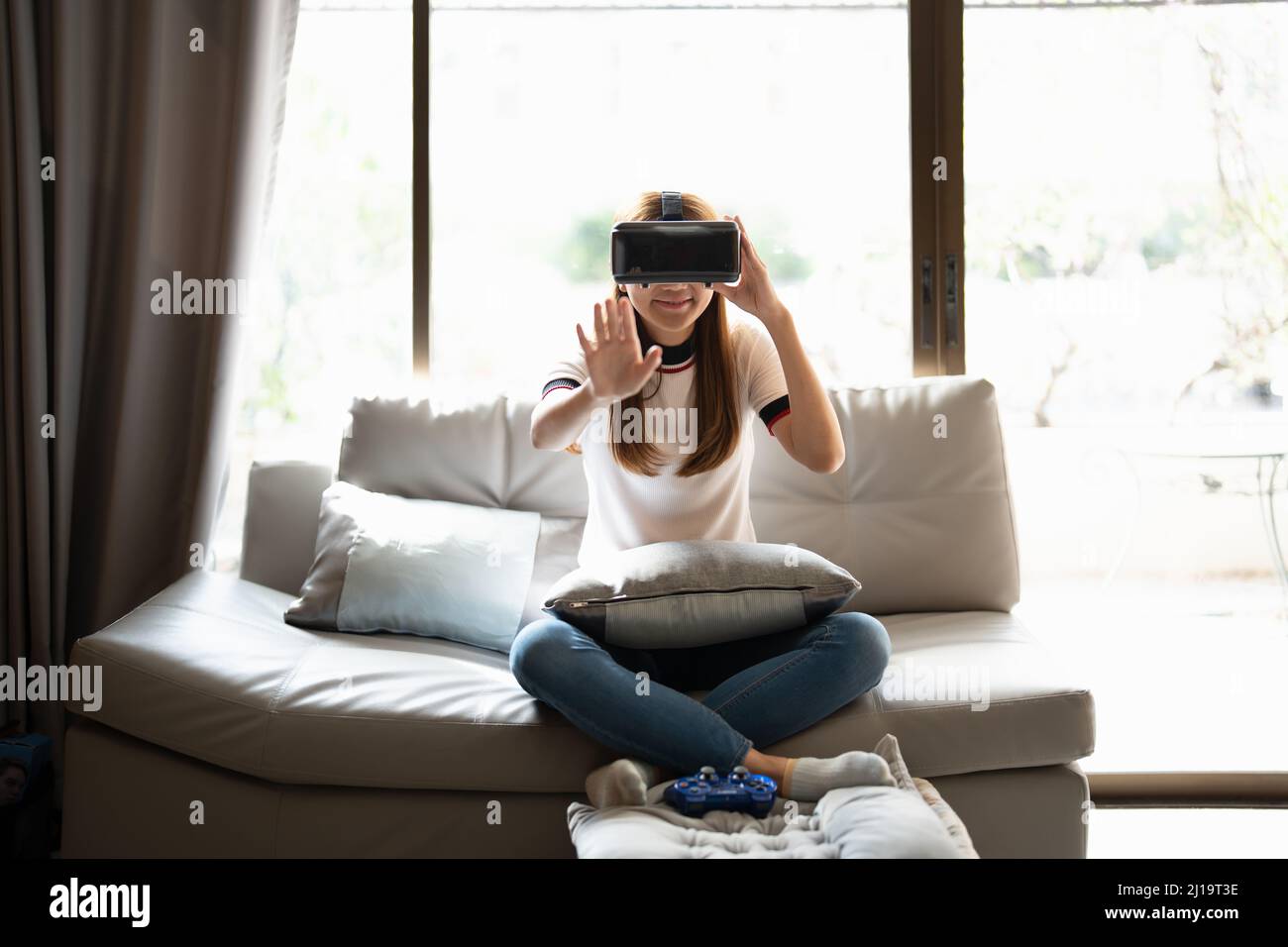 Concept de la technologie, jeux, divertissement et les gens.femme asiatique appréciant les lunettes de réalité virtuelle tout en se relaxant dans le salon.Happy jeune gars avec Banque D'Images