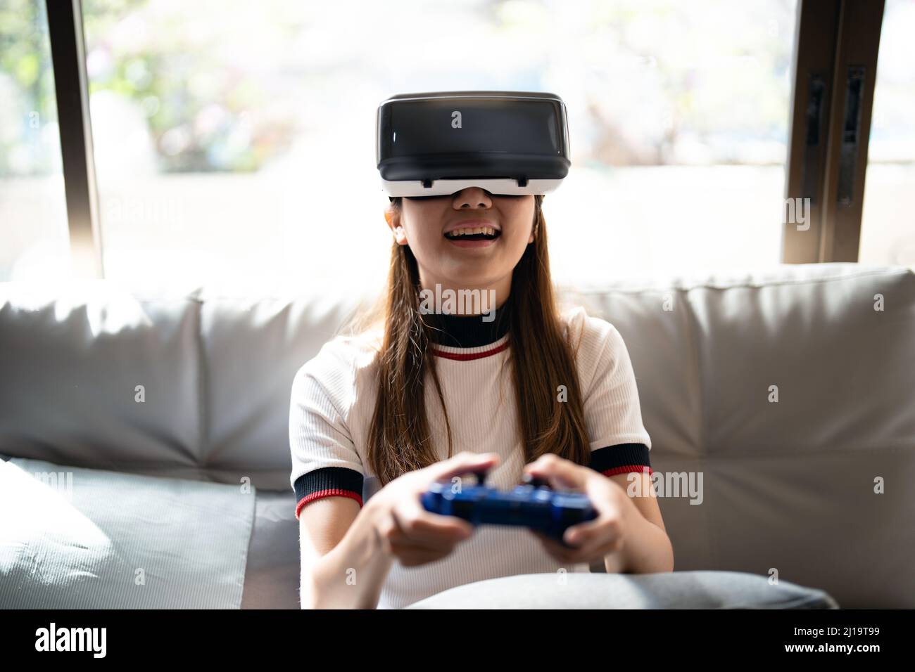 Concept de la technologie, jeux, divertissement et les gens.femme asiatique appréciant les lunettes de réalité virtuelle tout en se relaxant dans le salon.Happy jeune gars avec Banque D'Images