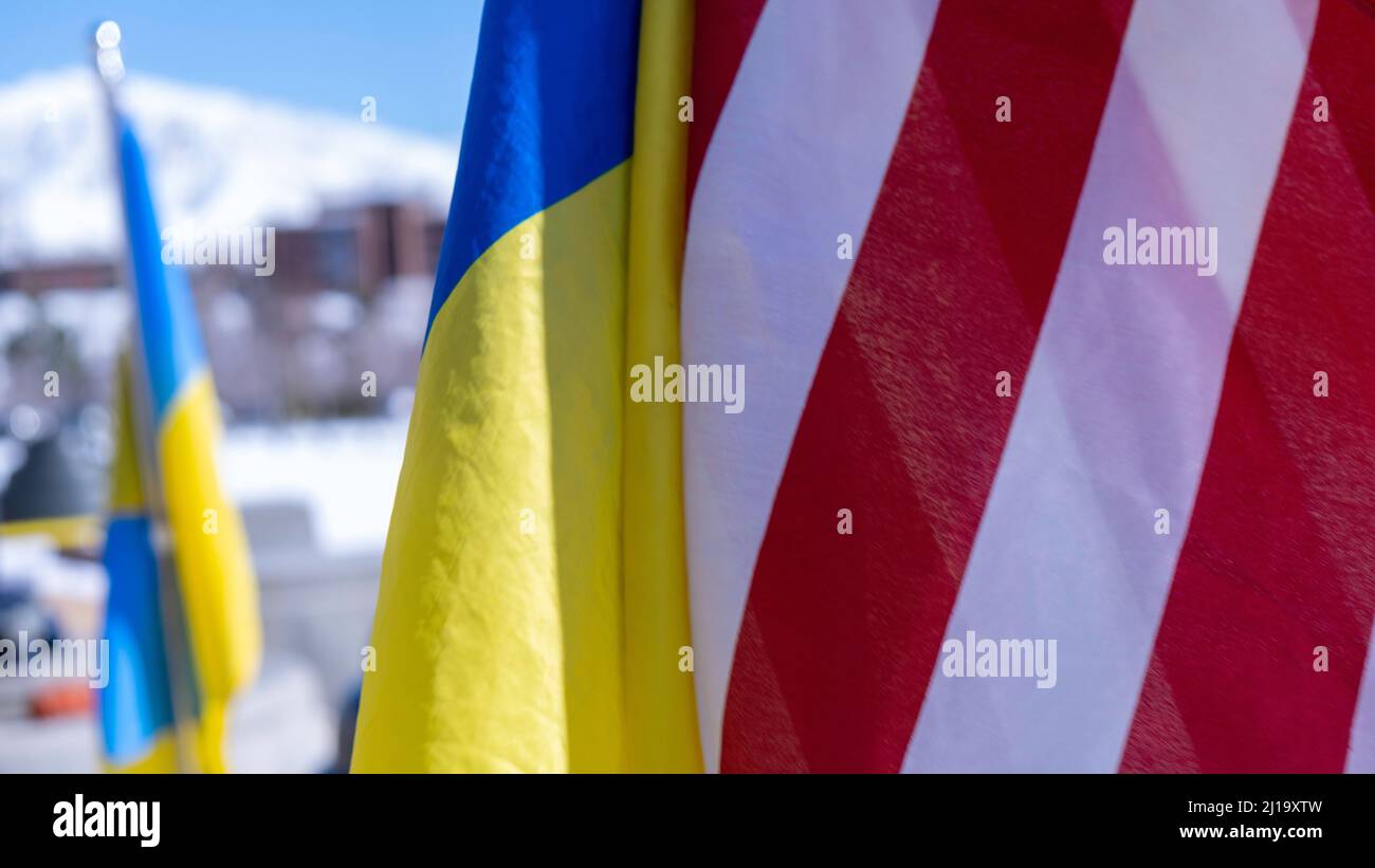 Gros plan sur les drapeaux des États-Unis et de l'Ukraine avec des montagnes enneigées en arrière-plan Banque D'Images