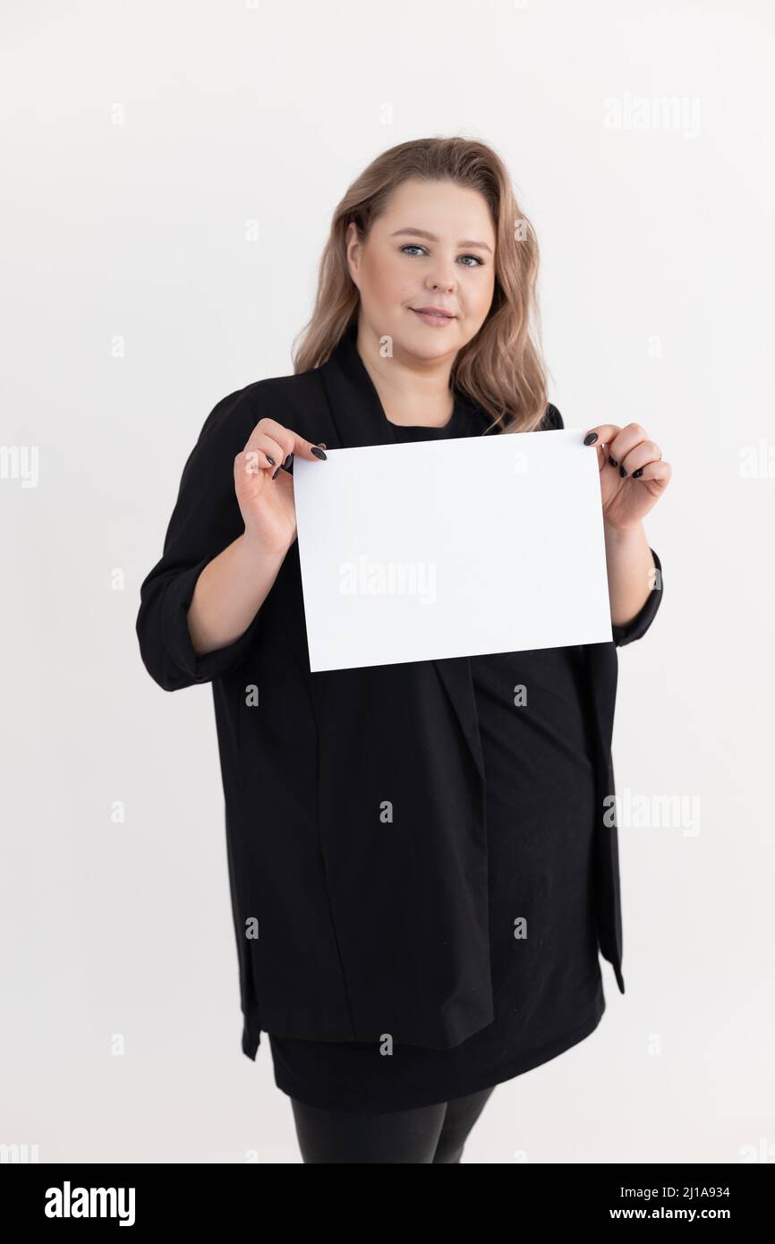 Sourire aux couleurs d'âge moyen gras plus-taille surpoids Plump femme avec maquillage tenant une feuille blanche vierge de papier. Banque D'Images