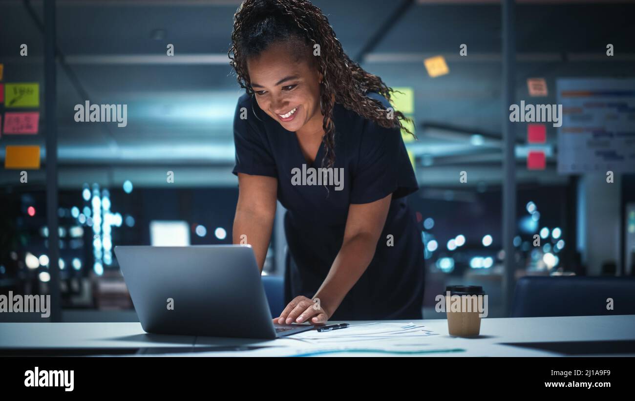 Portrait d'une femme d'affaires afro-américaine travaillant sur un ordinateur portable au bureau de Big City tard dans la soirée. Directrice générale féminine de DIGIT Banque D'Images