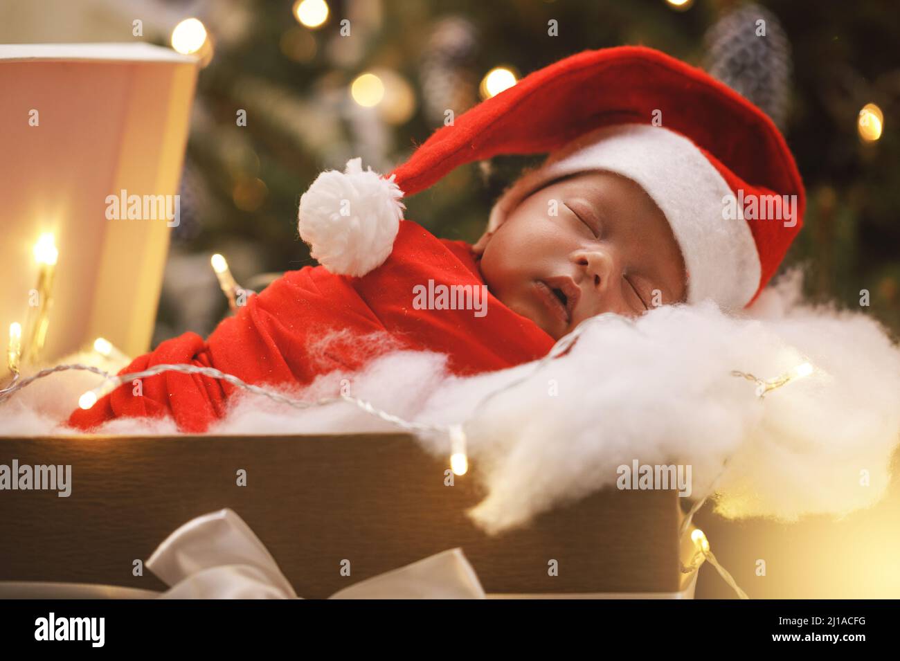 Bébé nouveau-né mignon portant le chapeau du Père Noël est de dormir dans  la boîte cadeau de Noël Photo Stock - Alamy